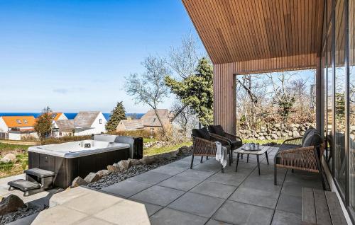 a patio with a hot tub and a table and chairs at Stunning Home In Hasle With Sauna in Hasle