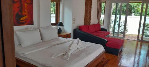 a bedroom with a bed and a red couch at Villa Ban Tai Zero, Master Bedroom Bungalow in Nathon Bay
