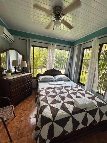 a bedroom with a bed and a ceiling fan at La Esmeralda Villa in Orotina