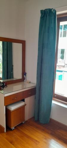 a bathroom with a vanity with a mirror and a blue curtain at Villa Ban Tai Zero, Master Bedroom Bungalow in Nathon Bay