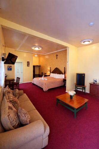ein großes Hotelzimmer mit einem Bett und einer Couch in der Unterkunft Hotel Fiesta Brava Inn Río Bravo in Primero de Mayo