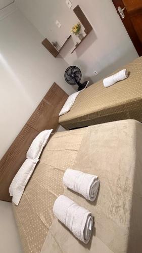 two beds in a room with towels on the floor at Cantinho Acolhedor com 4 cama e 2 quartos in Juazeiro do Norte