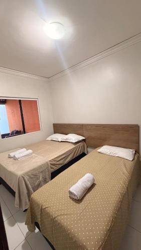 a room with two beds with towels on them at Cantinho Acolhedor com 4 cama e 2 quartos in Juazeiro do Norte