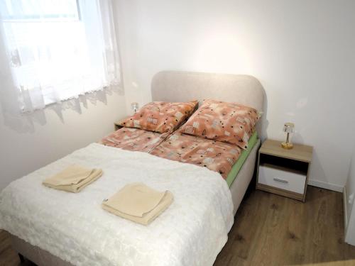 a bedroom with a bed with two towels on it at New apartment in Wise ka in Wisełka