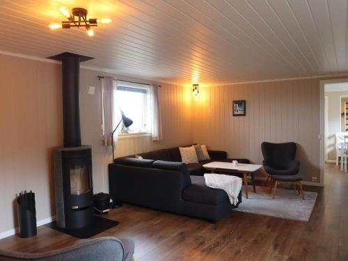 a living room with a couch and a fireplace at 7 person holiday home in Risør in Risør