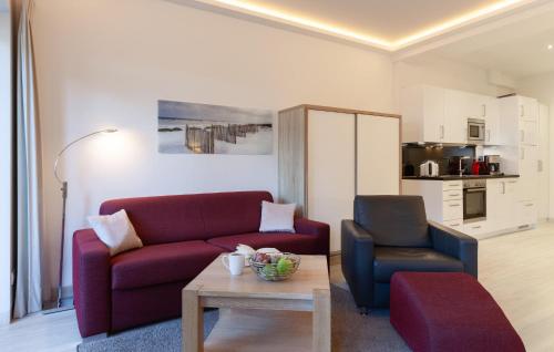 a living room with a red couch and a chair at Baltic in Binz