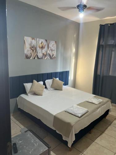 a bedroom with a large bed with two pillows at Hotel San Remo in Ubá