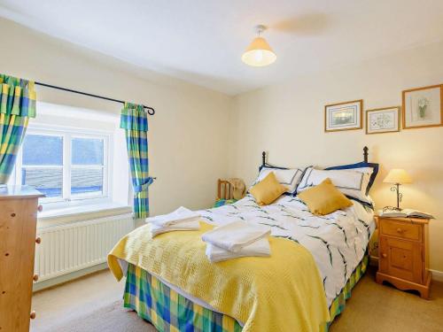 a bedroom with a bed with yellow sheets and a window at 2 Bed in Matlock oc-81116 in Crich
