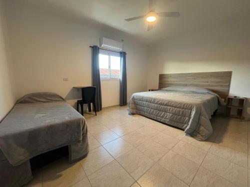 a bedroom with two beds and a window at Costumbres Argentinas Triples En suite in Avellaneda