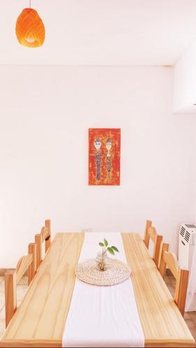 a dining room with a wooden table with a plant on it at PISO UNO - Gran Living Comedor y Habitación - PET FRIENDLY - AUTO CHECK IN 24 HS - Para 4 personas - No alquilamos a Bahienses por el momento in Bahía Blanca