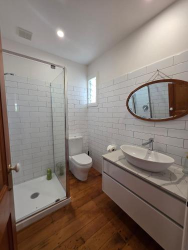 a bathroom with a sink and a toilet and a mirror at Kingfisher Lodge Waterfront Retreat in Tairua