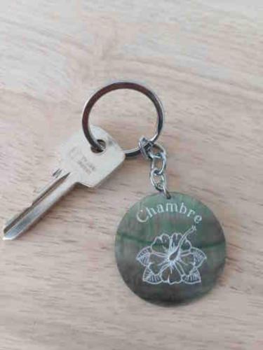 a key chain with a flower on it at TIARE - City center room Papeete in Papeete