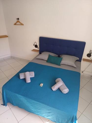 a blue bed with two pairs of towels on it at B787 - City center room Papeete in Papeete