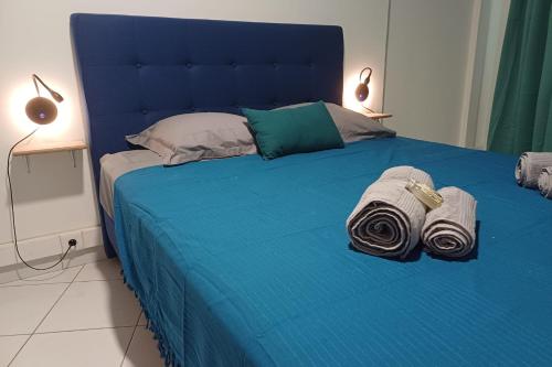 a blue bed with towels on it in a room at DREAMLINER - City center room Papeete in Papeete