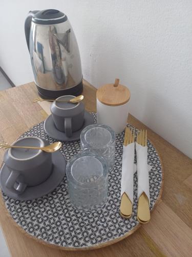 a table with a plate with a tea pot and utensils at HONEY - City center room Papeete in Papeete