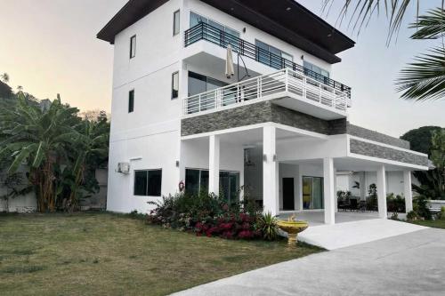 a white house with a balcony at Villa Fiesta, 5bd, palace in Mae Nam