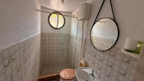 a bathroom with a toilet and a sink and a mirror at Suítes Recanto dos papagaios in Angra dos Reis