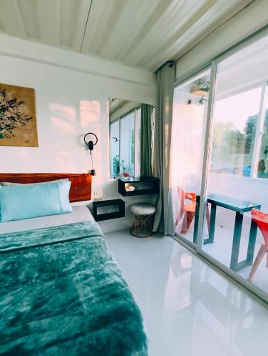 a bedroom with a bed and a table and window at Bougainvillea guesthouse in San Juan