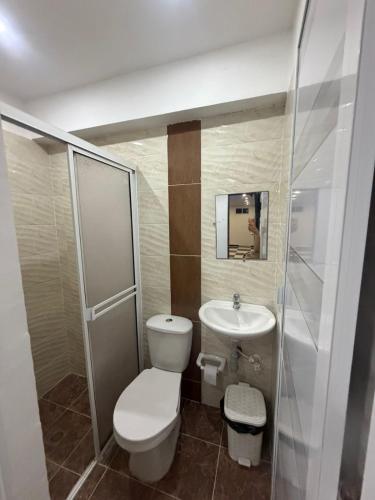 a small bathroom with a toilet and a sink at Hotel Pacífico Azul in Bahía Solano
