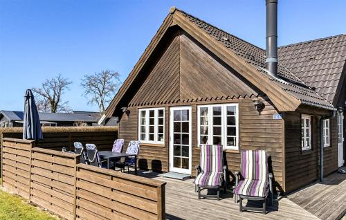 a deck with chairs and a table and a house at Holiday Home Bork Hytteby Hemmet Denmark in Hemmet