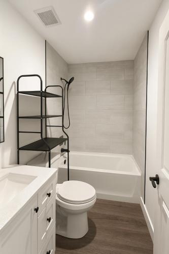 a white bathroom with a toilet and a bath tub at Modern LA Vacation House World Cup in Los Angeles
