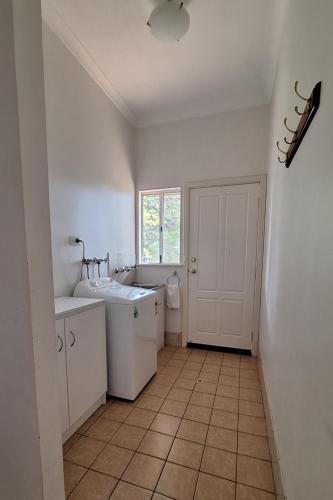 a white bathroom with a sink and a window at Abbivale Farm Cottage in Harewood