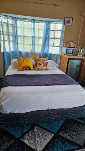 a bedroom with a large bed with blue curtains at Smithy's Apartment 2 in Ribishi