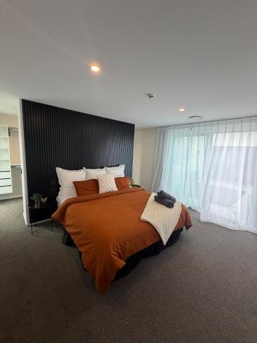 a bedroom with a large bed with orange sheets and pillows at Darfield Retreat in Darfield