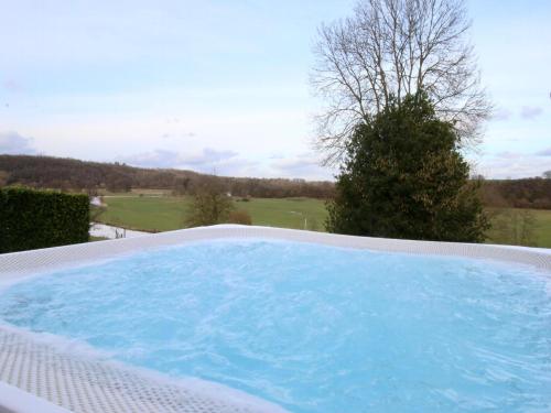 a large hot tub with a view of a golf course at Le Beau Souvenir, Noiseux in Noiseux