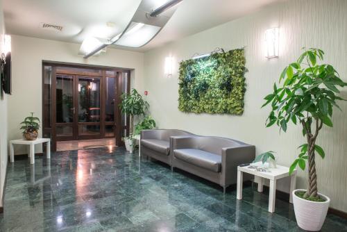 a waiting room with couches and plants at Hotel Relax Craiova in Craiova