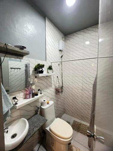 a bathroom with a toilet and a sink and a shower at Miestee's Happy Homes in Lapu Lapu City