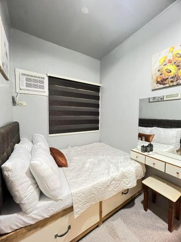 a bedroom with a large bed and a desk at Miestee's Happy Homes in Lapu Lapu City
