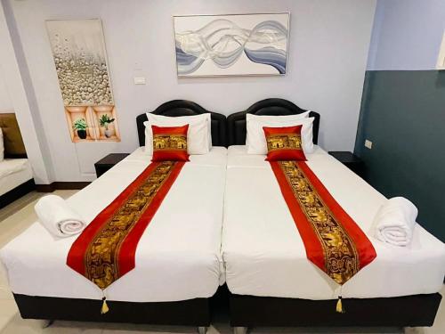 a bedroom with two beds with red and white sheets at Pongsakorn Boutique Resort in Lat Krabang
