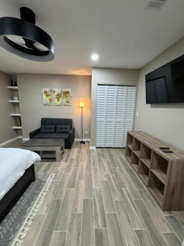 a bedroom with a bed and a couch and a television at VillaLuna Studio in Wellington