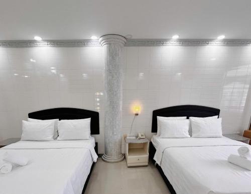 two beds sitting next to each other in a room at KT SG Hotel - Center in Ho Chi Minh City