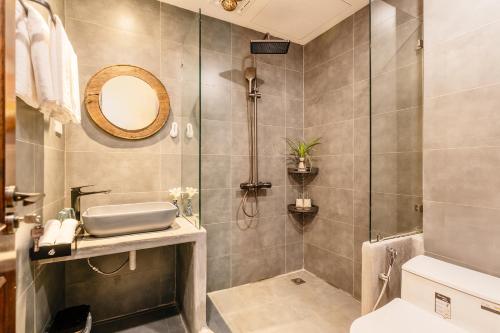 a bathroom with a shower and a sink and a mirror at Về Homestay Ninh Bình in Ninh Binh