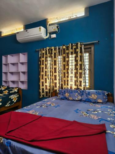 a bedroom with a bed with blue walls and a window at krishna yadav homestay in Hospet