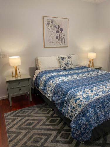 a bedroom with a bed and two lamps and a rug at Eastern Suburbs Gem in Forest Hill