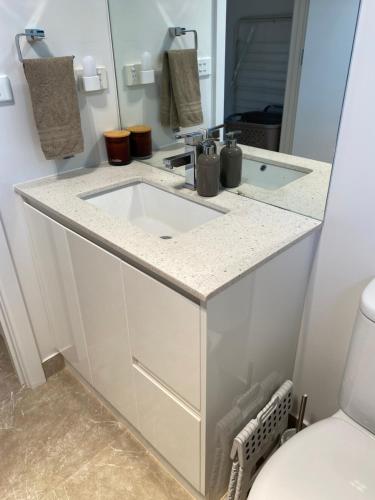 a bathroom with a white sink and a toilet at Eastern Suburbs Gem in Forest Hill