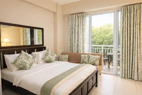 a bedroom with a large bed and a balcony at Nade Suites - Pico De Loro MIB 601 in Nasugbu