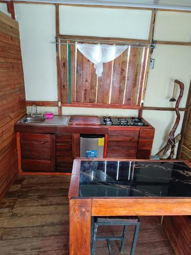a kitchen with a stove and a wooden table at Cabañas Ecológicas in Tela in Tela