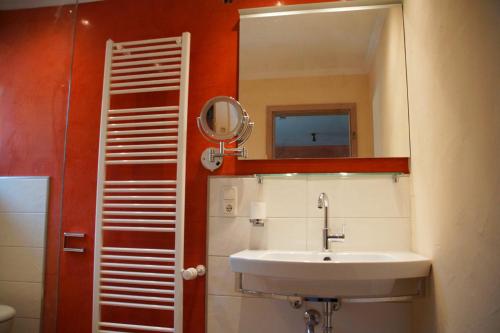 a bathroom with a sink and a mirror at Landkomforthotel Panorama & Restaurant Bella Vista in Garmisch-Partenkirchen
