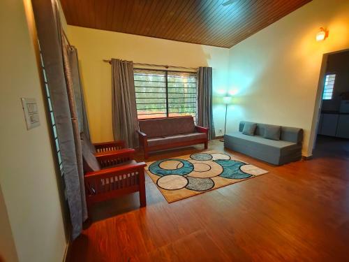 a living room with a couch and a chair at Himabindu Stays in Sakleshpur