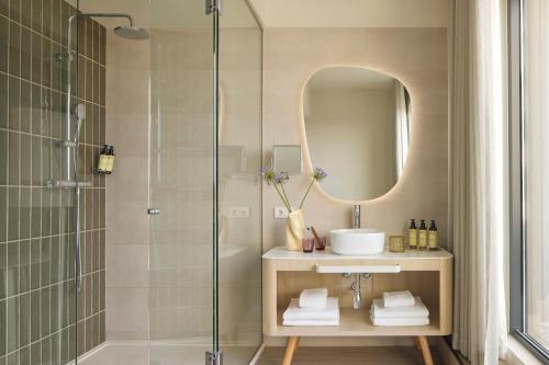 a bathroom with a shower and a sink and a mirror at ME by Meliá Sitges Terramar in Sitges