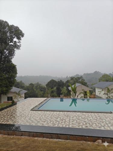 a swimming pool in front of a house at Himabindu Stays in Sakleshpur