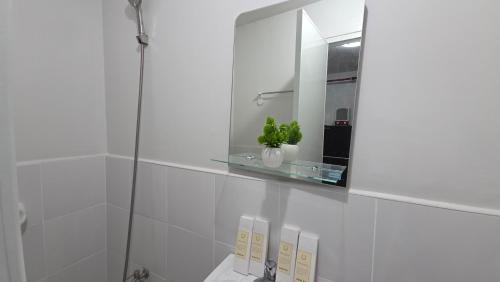 a bathroom with a glass shelf above a toilet at Plumera Mactan Condo unit in Bankal