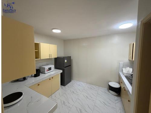 a small kitchen with a refrigerator and a microwave at Forest View Leisure Residences in Olongapo