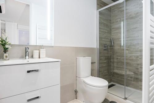 ein Bad mit einem WC und einer Glasdusche in der Unterkunft BNBHolder Luxury Apartment II PLAZA DE ESPAÑA in Madrid