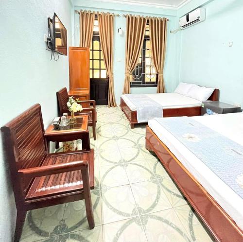 a bedroom with two beds and a table and chairs at Ks DŨNG HOA MAI in Sầm Sơn
