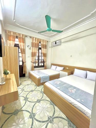 a bedroom with two beds and a ceiling fan at Ks DŨNG HOA MAI in Sầm Sơn